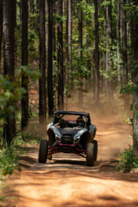 2027 Kawasaki TERYX H2 LIMITED eS charging down a wooded trail toward the camera during testing.